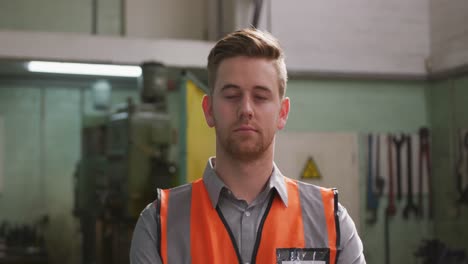 caucasian male factory worker at a factory wearing a high vis vest