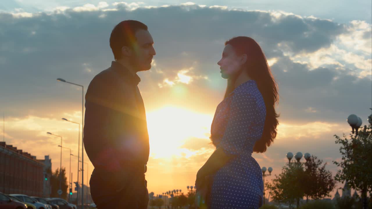 hombre y mujer hablando durante la puesta de sol.