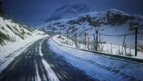 snow covered road winding through mountain landscape during twilight