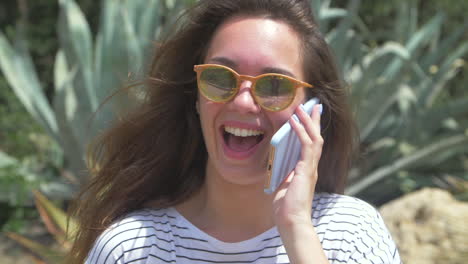 a happy young woman talking on her phone outdoors