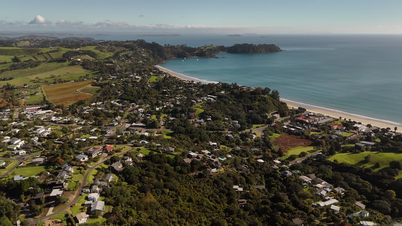 Houses surrounded by trees near the beach of Onetangi bay in Waiheke Island, aerial shot