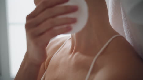 woman hand rubbing neck with lotion home close up. unknown girl using cotton pad