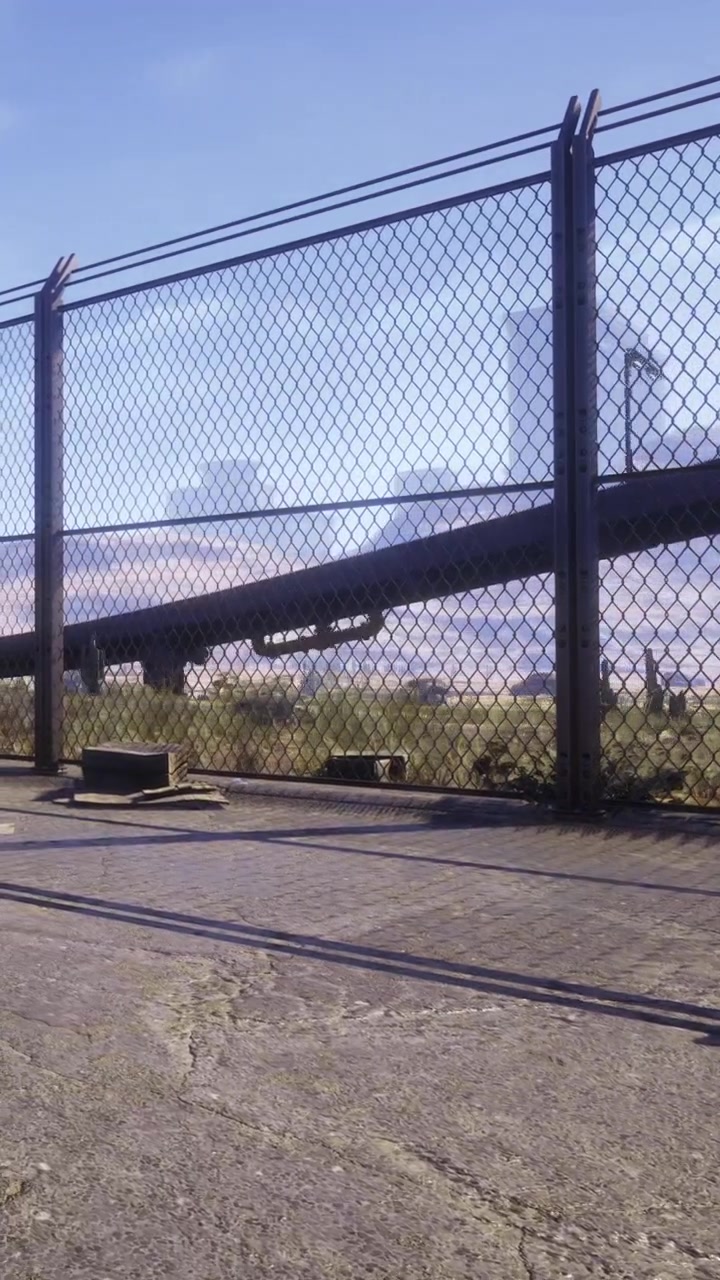 Vista di un'area recintata con un'autostrada e terreno erboso sullo sfondo