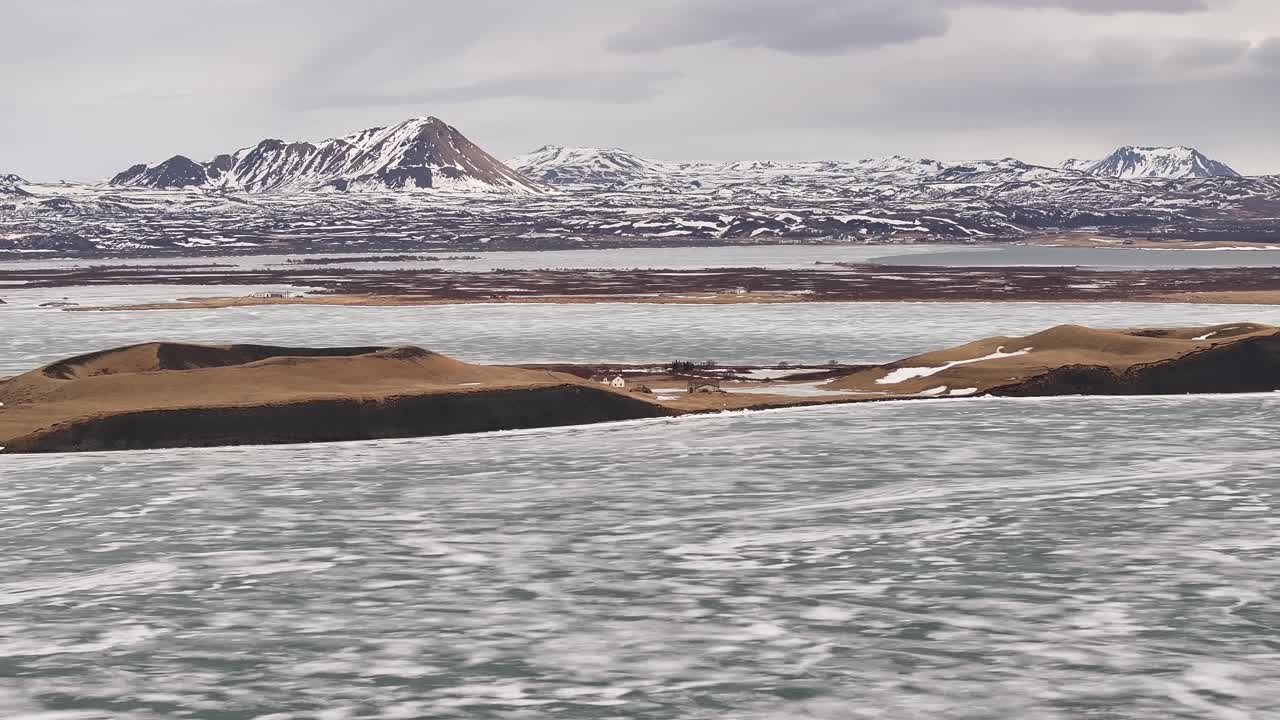 frozen lake Mývatn and snow mountains frame volcanic landforms in Skútustaðir Reykjahlíð Iceland