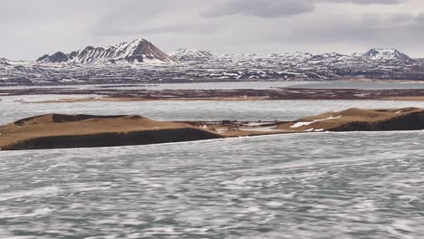 frozen lake mývatn and snow mountains frame volcanic landforms in skútustaðir reykjahlíð iceland