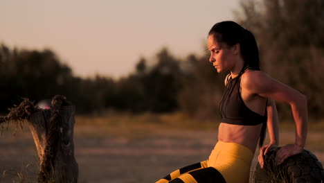 Push-ups-or-press-ups-exercise-by-young-woman.-Girl-working-out-on-grass-crossfit-strength-training-in-the-glow-of-the-morning-sun-against-a-white-sky-with-copyspace.