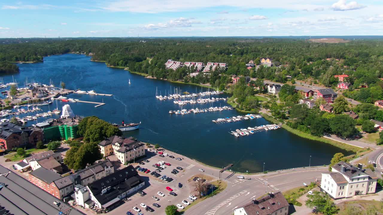 Vol panoramique en drone au-dessus du port de plaisance de Gustavsberg, avec des bateaux amarrés dans le magnifique archipel de Stockholm. Panoramique vers un chantier de construction