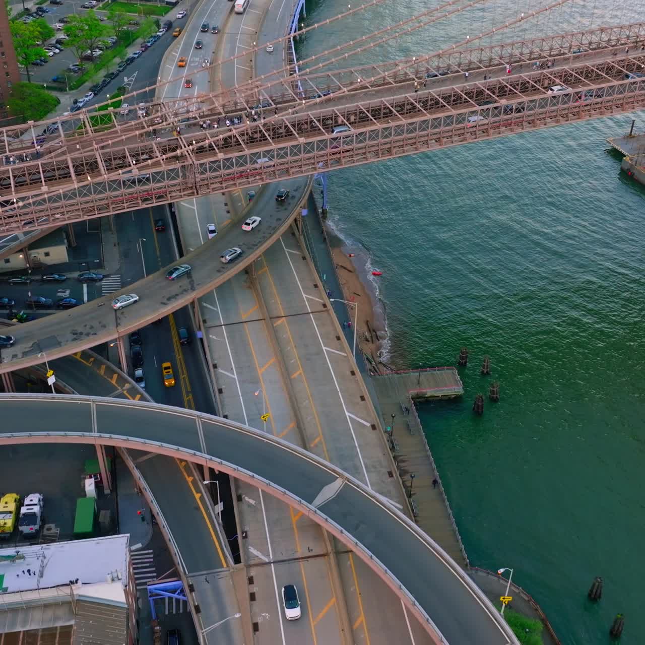 Road junctions under Brooklyn bridge. Busy traffic of New York city. View from above