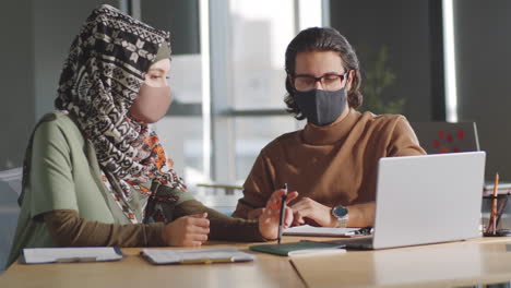 Muslim-Colleagues-in-Masks-Discussing-Business-in-Office