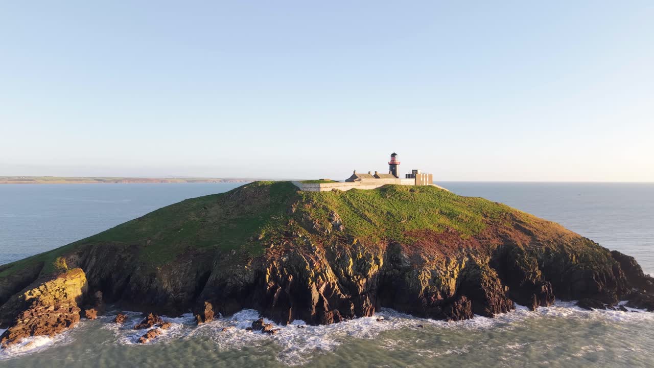 Ballycotton Lighthouse on a green island, surrounded by the Atlantic under soft light