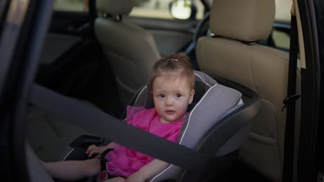 a baby girl in a car seat