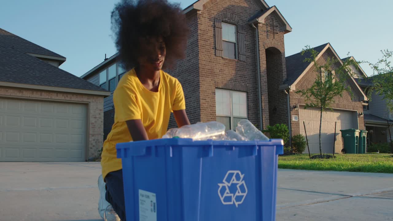 African American adolescence placing plastic bottles in recycle bin
