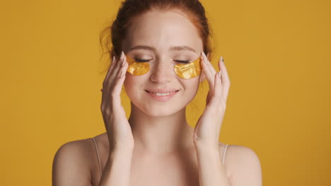 redheaded girl in front of camera on yellow background.