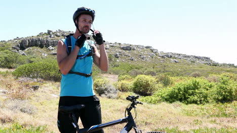 man going cycling putting helmet on