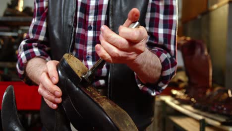 shoemaker repairing a shoe