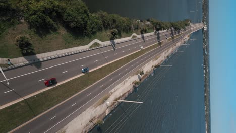 tracking vertical drone shot flying over coastal causeway - indian river lagoon