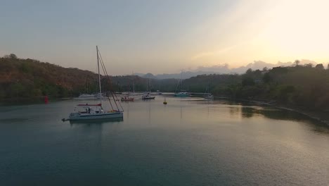 Abendlicher-Ruhiger,-Subtiler-Goldener-Sonnenuntergang-über-Yachten-In-Abgelegener-Bucht-Luftaufnahme