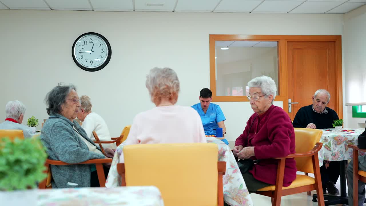 Elderly people in a nursing home with a nurse