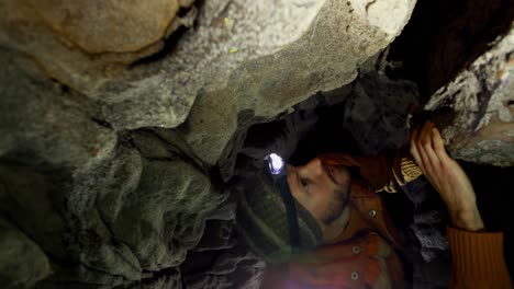 excursionista masculino explorando una cueva oscura 4k