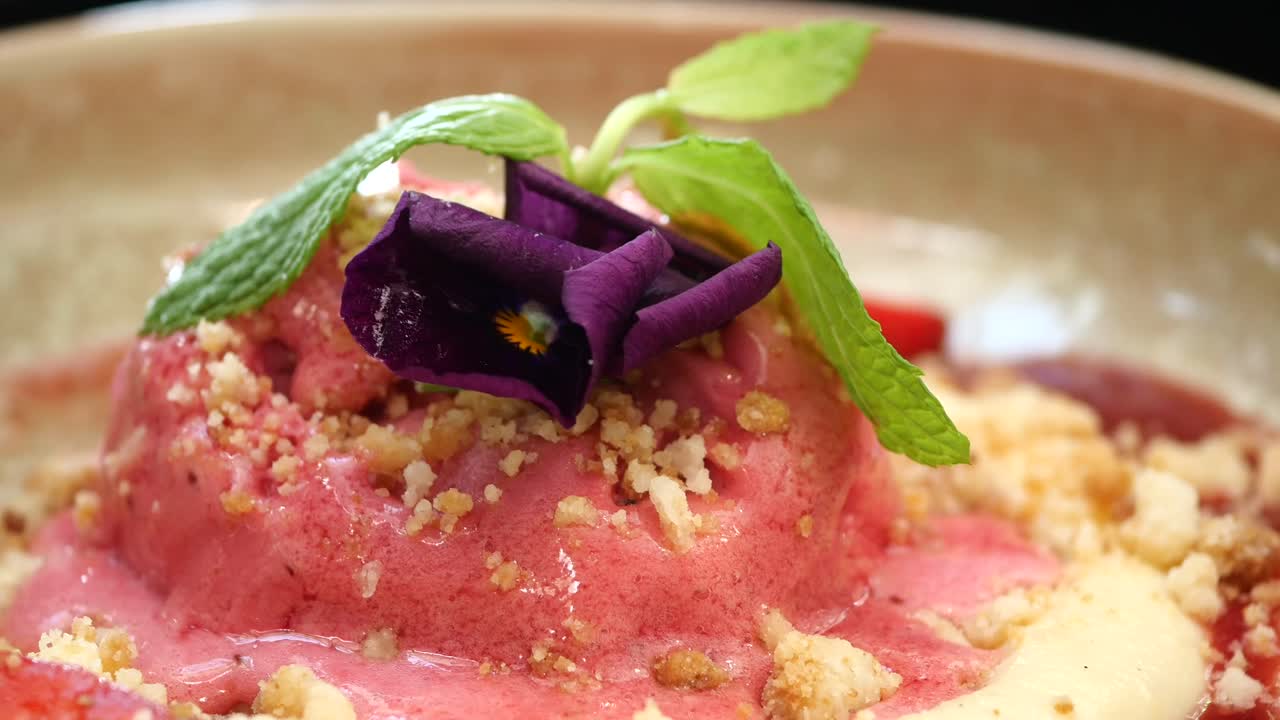 Lähikuva gourmet-mansikkajäätelöjälkiruoasta syötävällä kukalla