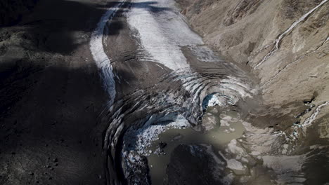 debris covered pasterze glacier at the foot of grossglockner mountain, melting glacier due to global warming, drone shot