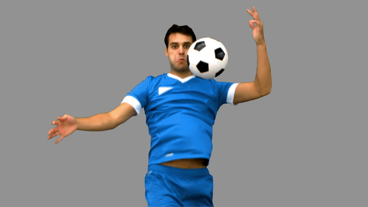 회색 화면에 그의 가으로 축구를 통제하는 잘생긴 남자