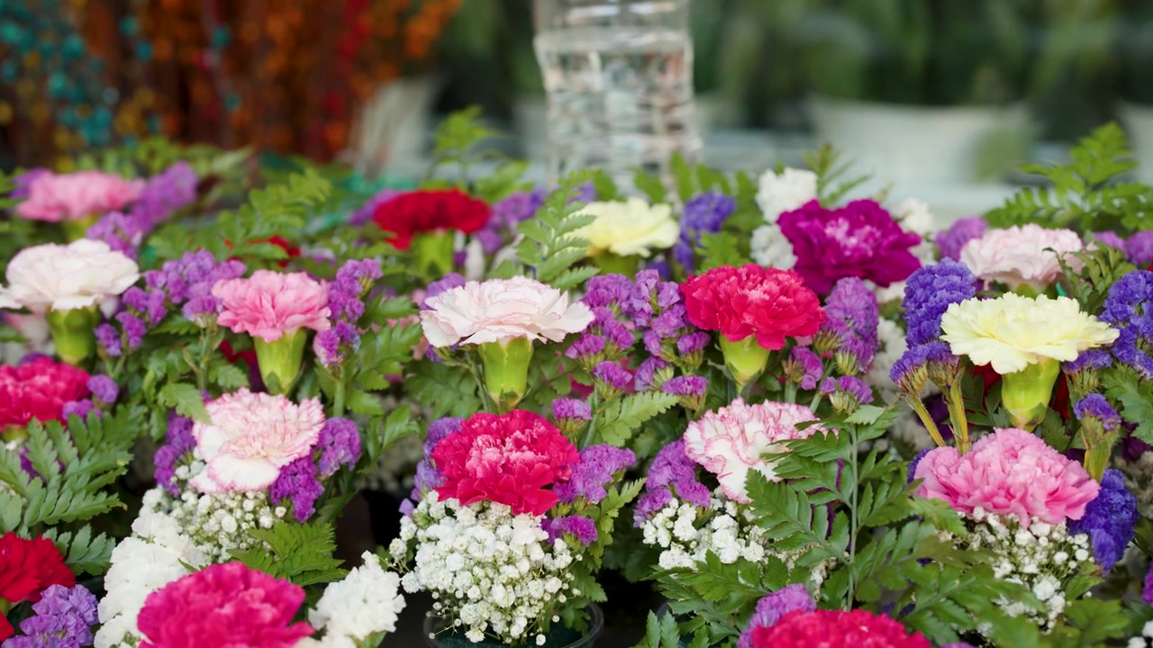 Close-up of vibrant pink, red, and purple floral arrangements at Bangkok Flower Market, Thailand.