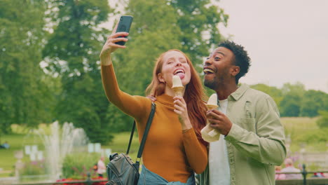 una joven pareja viajando por la ciudad juntos comiendo helados en el parque