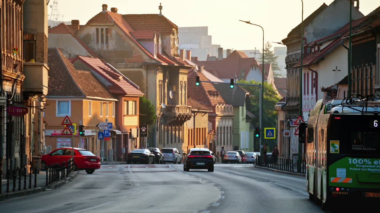 BRASOV, ROMANIA - AUGUST 27, 2023: Street view of the town. Old residential buildings, road with moving cars