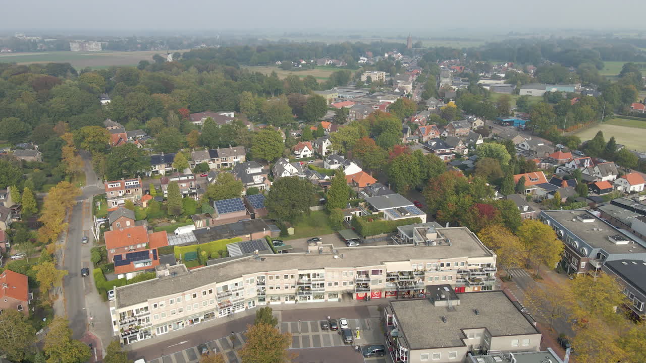 Jib-opname naar beneden van een klein winkelcentrum in de voorstad met een bijna lege parkeerplaats