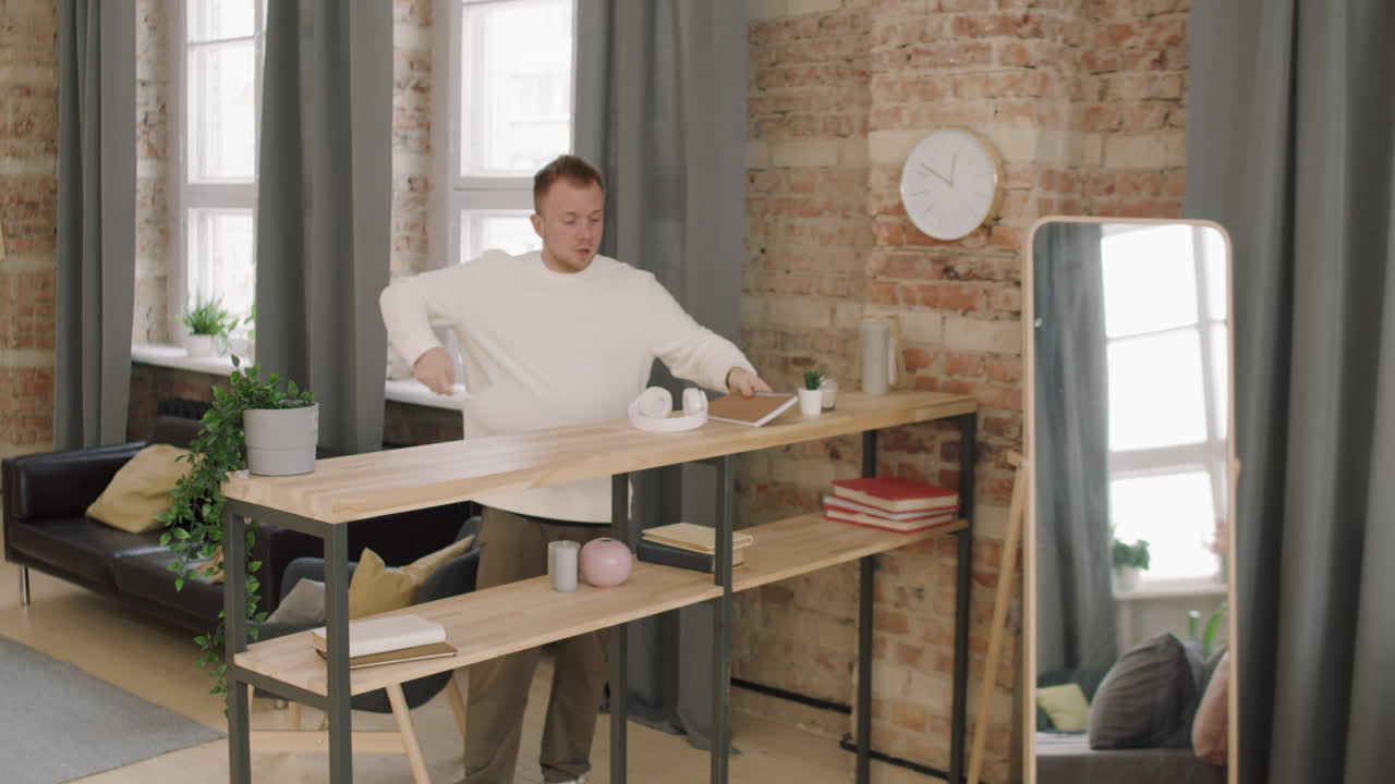 Young Man Dancing and Dusting at Home