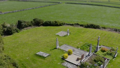 extremely fast dizzying pullback from grass field to stone wall over cemetery