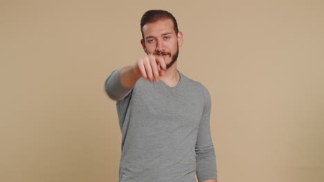 Smiling-young-man-makes-heart-gesture-demonstrates-love-sign-expresses-good-feelings-and-sympathy