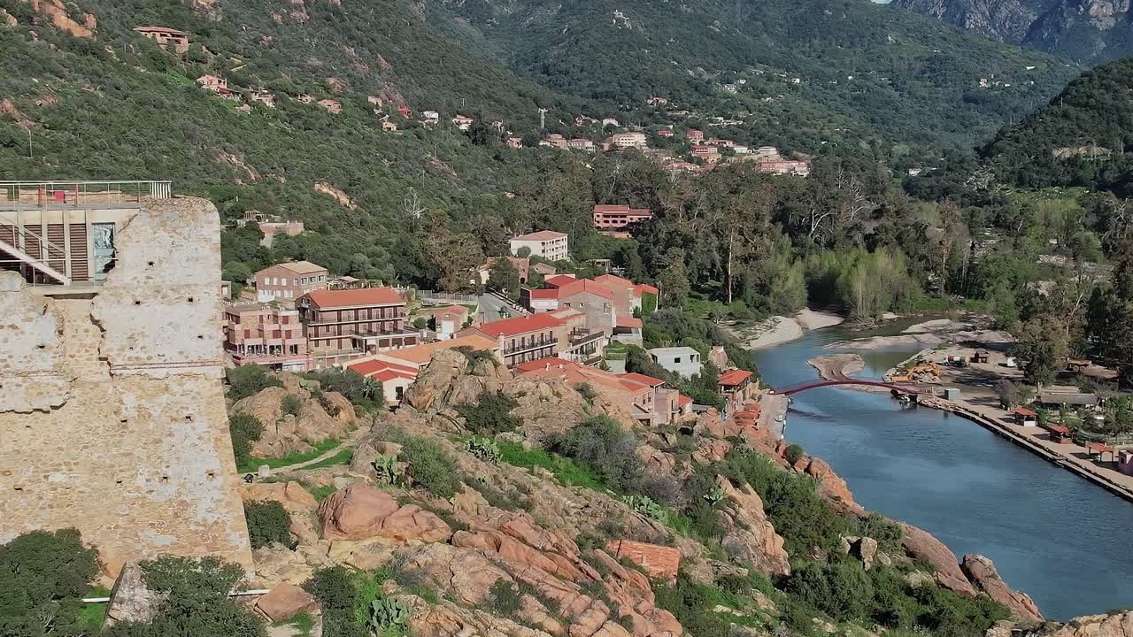 Corsica's landscape where houses sit near a river