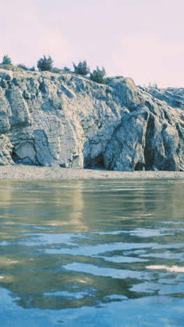 rocky shoreline with reflections during calm water at sunset