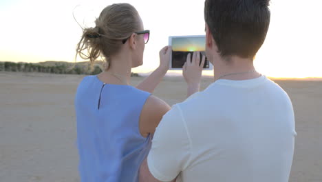 Young-people-taking-pictures-of-sunset-on-the-shore