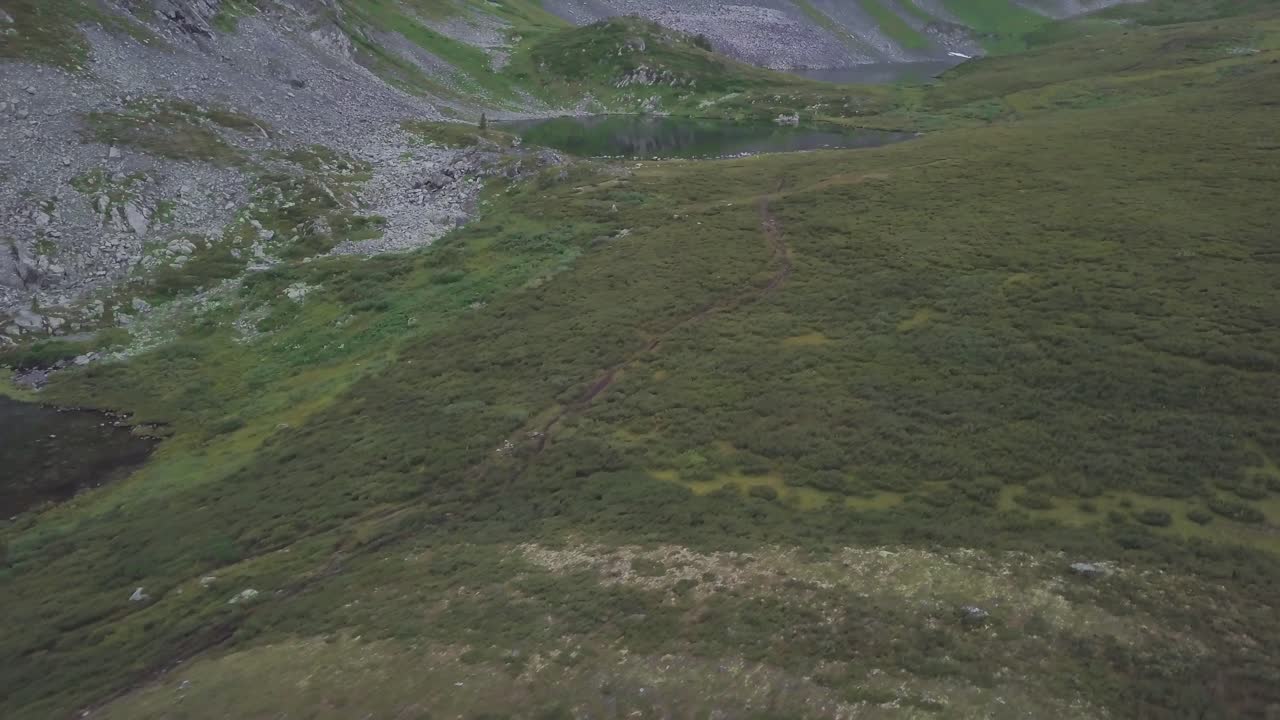 paisaje de valle de montaña con lago y senderos