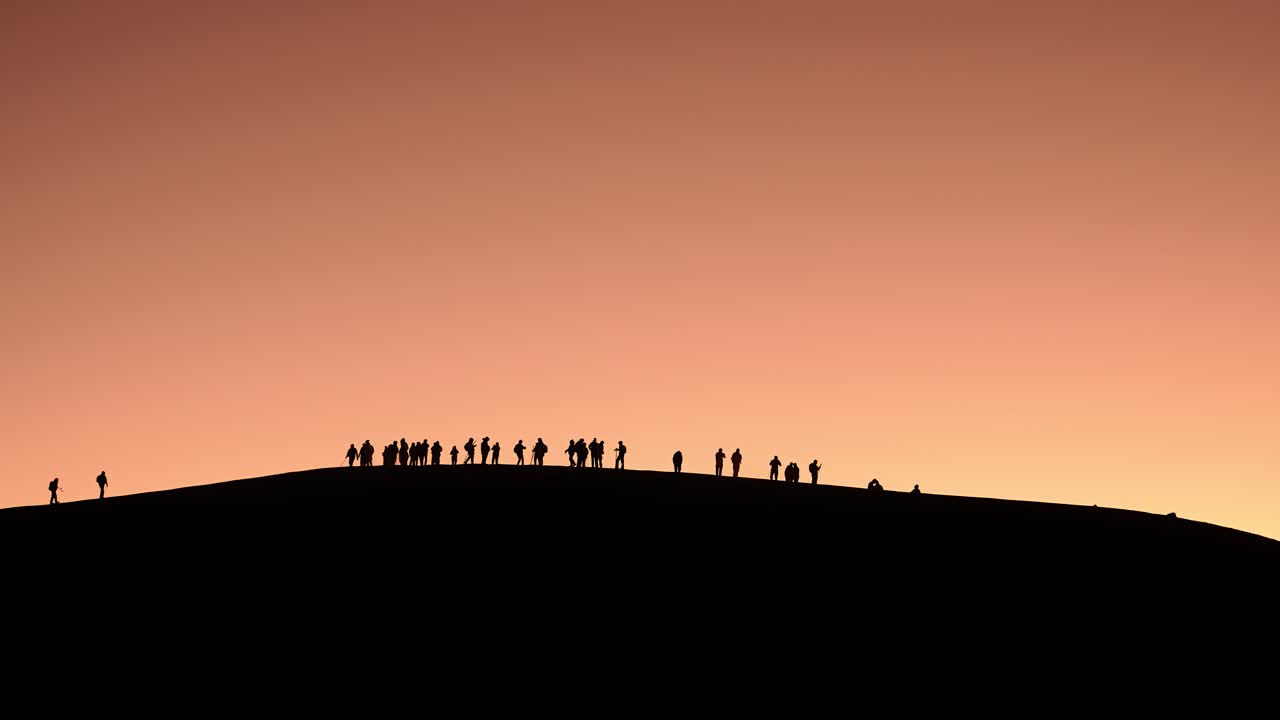 Silhouetted hikers on ridge at sunset near Fuego Volcano Guatemala skyline