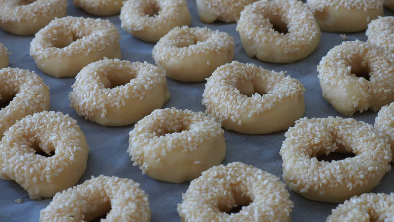 Close-up sesame seeds stuck to the dough, tiny bagels with sesame seeds,