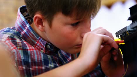 schoolboy repairing a printer in the classroom