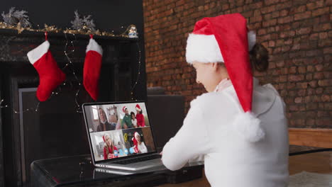 mujer caucásica pasando el tiempo en casa con sombrero de papá noel