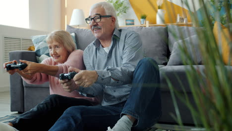 senior couple playing video games at home