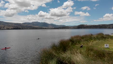 dron flying backwards revealing two kayacks on the lake san pablo near the shore