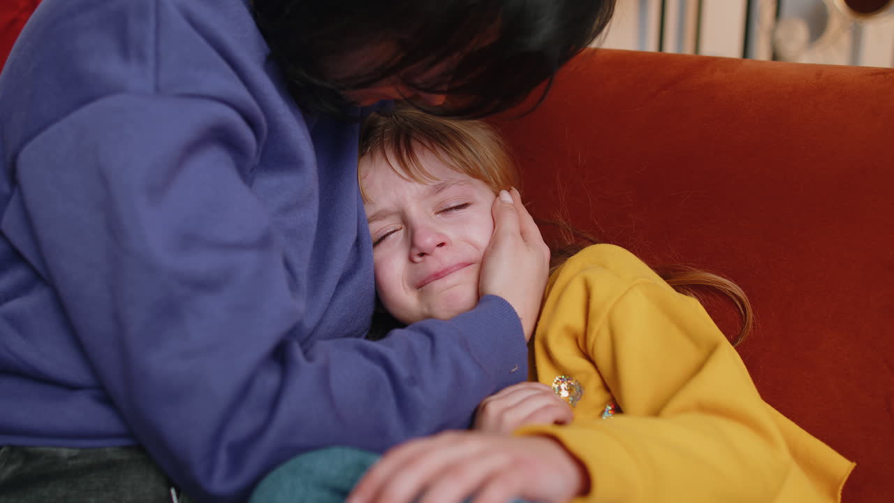 Close-up di una ragazza triste che piange e giace sulla madre a casa violenza contro i bambini in famiglia