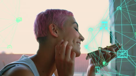 animación de globos de iconos digitales girando sobre una mujer biracial feliz hablando en un teléfono inteligente