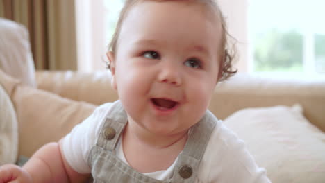 happy baby boy playing on sofa at home