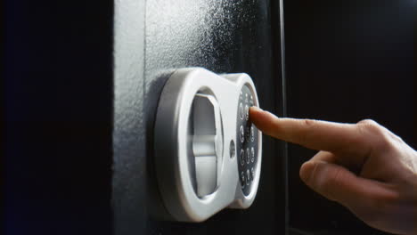 hand closing strongbox door closeup. person entering combination to lock safe.