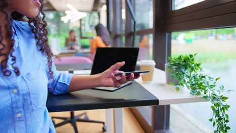 Businesswoman-Working-At-Desk-In-Office-Taking-Call-Talking-Into-Mic-Of-Mobile-Phone