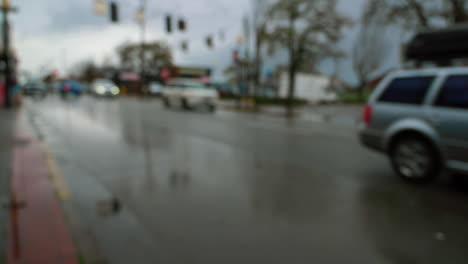 blurred city traffic, cars driving on wet road during rainy day