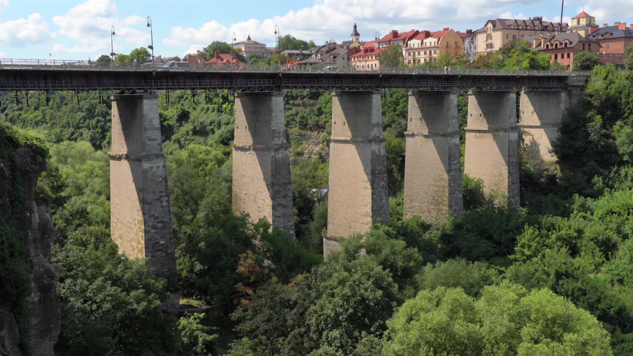 Aerial view of Old Bridge at Kamyanets-Podilskyi,Ukraine on a sunny day with white clouds.Ascending slowly.